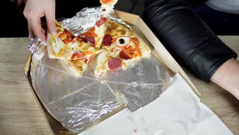 Nahaufnahme-der-Menschen-Hände-nehmen-Scheiben-Pizza-aus-Essen-Lieferung-offener-Kasten.-Leckere-Service-Büro.-Änderungen-an-Händen-zu-konzentrieren.-Schuss-in-4k