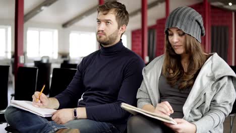 Closeup-view-of-young-man-and-womam-taking-notes-during-the-presentation.-Shot-in-4k.