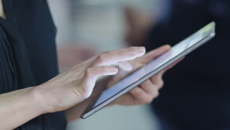 Close-up-shot-of-a-businesswoman-using-a-tablet-computer-in-the-office.