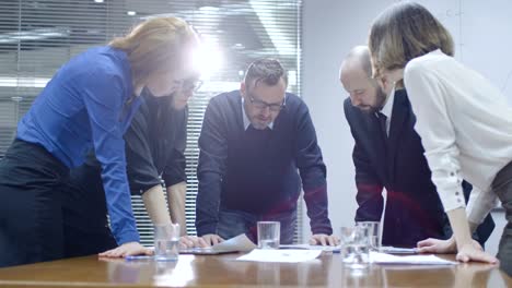 Employee-is-making-a-presentation-for-a-team-of-colleagues-that-are-sitting-in-a-meeting-room.