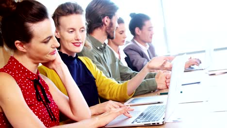 Smiling-business-team-interacting-with-each-other-in-conference-room