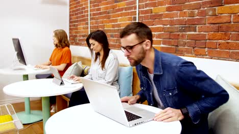 Group-of-executives-working-over-electronic-devices-at-desk