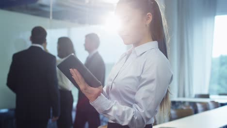 Geschäftsfrau-nutzt-Tablet-in-Crowded-Office