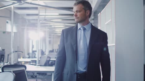 Businessman-walking-through-Office.