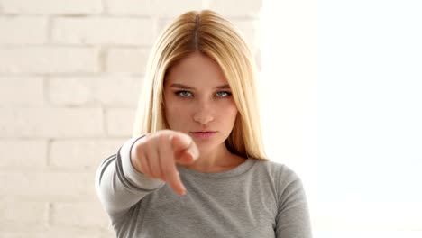 Portrait-of-Young-Woman-Pointing-at-Camera-in-Office