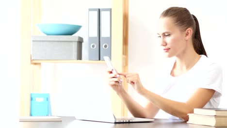 Mujer-mediante-aplicaciones-para-teléfonos-inteligentes-en-el-trabajo-en-oficina