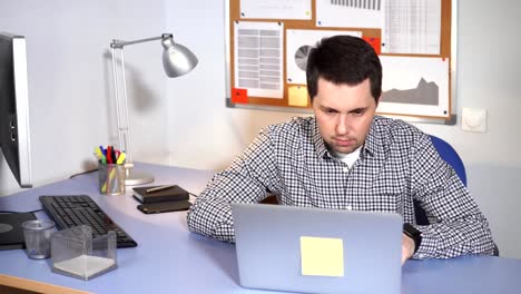 Kaufmännische-Angestellte-bei-der-Arbeit.-Mann-am-Schreibtisch-und-Laptop-verwenden.