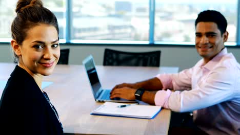 Businesswoman-and-colleague-sitting-together-in-office