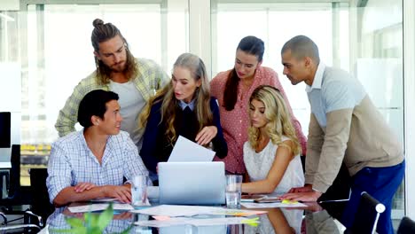 Colleagues-interacting-with-each-other-at-table-4k