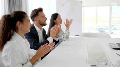 Lächeln-und-klatscht-an-Tisch-im-Business-Center,-glücklich-Unternehmensgruppe-Händeklatschen-in-Zeitlupe