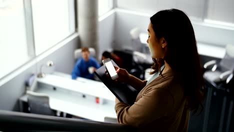 Mujer-ejecutiva-utilizando-teléfono-móvil