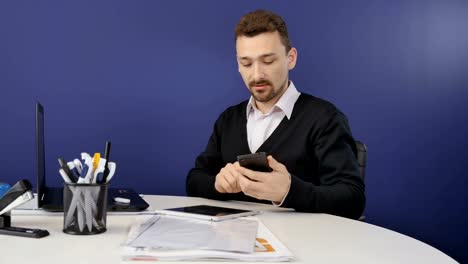 Handsome-businessman-talks-on-phone-in-the-office