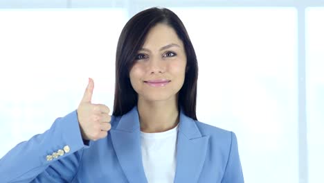 Thumbs-Up-by-Young-Businesswoman-in-Office