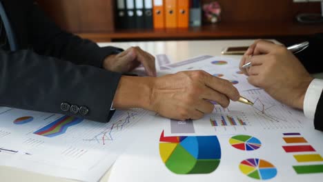 Businessman-examining-graphs-with-other-working-people.