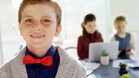 Boy-as-business-executive-smiling-while-standing-in-office--4k