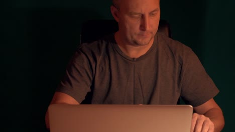 Adult-caucasian-man-entrepreneur-businessman-working-late-night-at-computer.-Close-up-front-view.-Lockdown-shot.