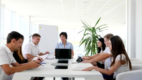 Chefin-vor-Laptop-auf-Treffen-mit-Partnern-diskutieren-Ideen-Geschäftsentwicklung-in-modernen-Sitzungssaal