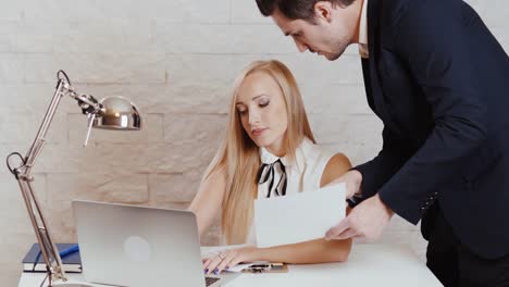 man-and-woman-are-working-on-a-computer-with-documents