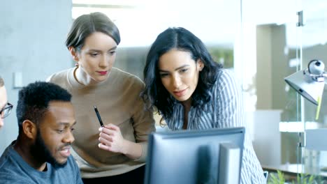 En-la-oficina-de-la-corporativa-ocupada-mujer-hispana-se-une-al-equipo-de-trabajo-de-diversos-jóvenes-creativos-en-la-solución-de-un-problema.-Colectivamente-intentan-ayudar-a-compañero-de-trabajo-para-resolver-el-problema.