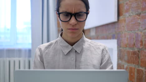 Hispanic-Frau-aufgeregt-durch-den-Verlust-während-der-Arbeit-am-Laptop