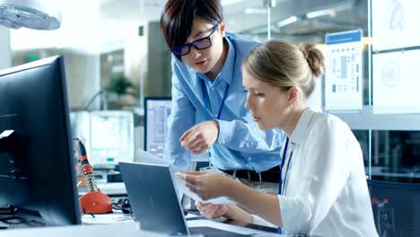 Two-Computer-Engineers-Work-with-Documents.-In-The-Background-Technologically-Advanced-Scientific-Research-Center.