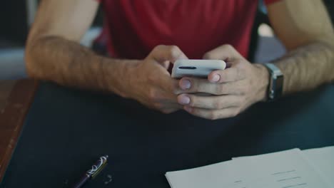 Männliche-Hände-mit-Telefon.-Nahaufnahme-eines-männlichen-Hand-Mitteilung-zu-schreiben,-auf-dem-Iphone-im-Büro