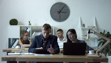 Colleagues-working-on-multimedia-devices-in-office