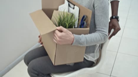 Excited-Woman-Riding-Chair-in-Office-Hallway