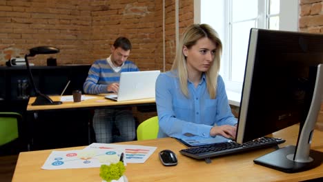 Closeup.-Porträt-einer-schönen-jungen-Frau-und-Mann,-die-auf-dem-Computer-im-Büro-arbeiten.