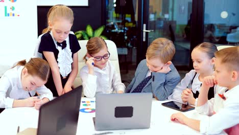 Young-and-bright-modern-small-creative-children-business.-Modern-office.-Children-discuss-business-ideas