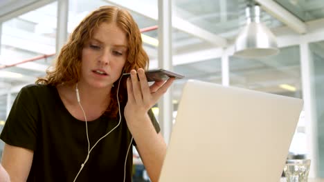 Mujer-de-negocios-hablando-por-teléfono-móvil-en-el-escritorio-4k