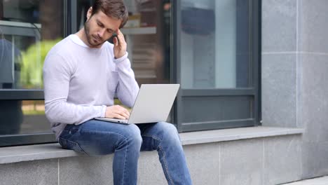 Angespannte-gut-aussehender-Mann-mit-Kopfschmerzen-arbeiten-am-Laptop-sitzt-draußen-Büro