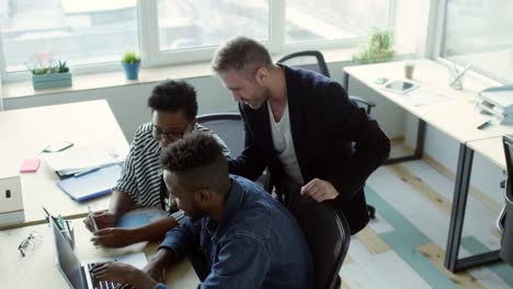 Mixed-Raced-Coworkers-Discussing-Information-on-Laptop-Screen