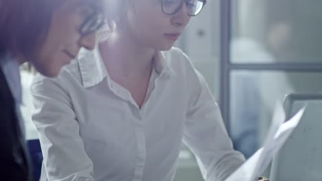 Business-Ladies-Discussing-Documents-at-Work