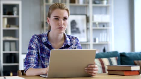 Young-Woman-Working-On-Laptop,-Sittting-on-Sofa-inOffice