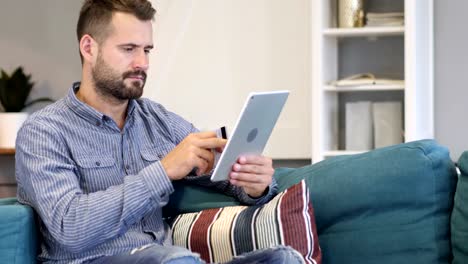 Online-Shopping-auf-Tablet-PC-sitzen-Mann