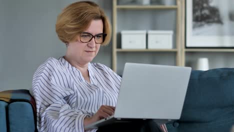 Senior-Woman-Online-Video-Chat-auf-Laptop-bei-der-Arbeit