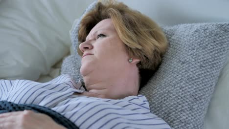Mujer-Senior-viejo-cansada-con-dolor-de-cuello-durmiendo-en-la-cama