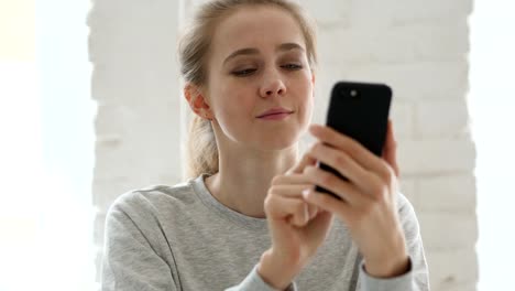 Mujer-joven-en-Smartphone-en-el-trabajo-de-Loft