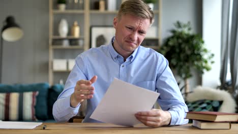 Businessman-Upset-after-Reading-Documents-at-Work