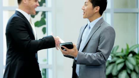 Multi-ethnic-male-female-team-meeting-with-tablet