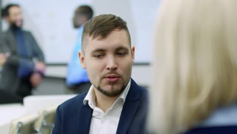 Young-Office-Worker-Having-Discussion-with-Female-Colleague