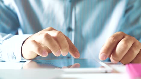 Young-businessman-working-with-tablet-and-and-reads-email-in-his-office-at-the-workplace