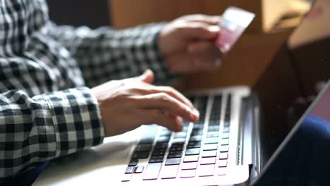 Close-up-hands-using-laptop-computer-with-credit-card-for-online-shopping