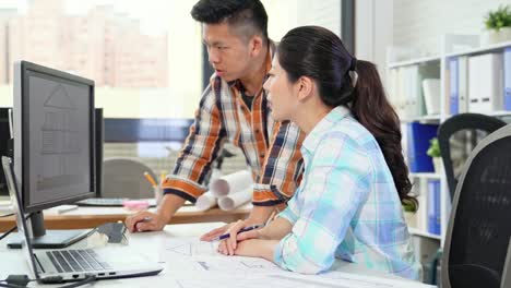 colleagues-discussing-work-on-a-laptop-computer