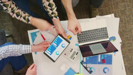 Overhead-Of-Colleagues-Discussing-Financial-Strategy-On-Digital-Tablet-4K