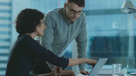 Beautiful-Female-Executive-Listens-to-Her-Project-Manager-Giving-Advise,-Pointing-at-Data-Shown-on-a-Laptop.-Businesspeople-Having-Discussion-in-the-Office.