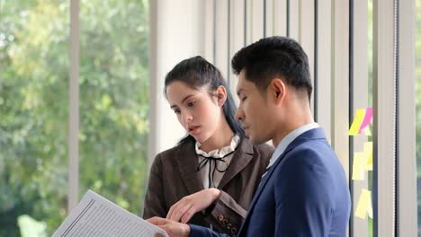 Businessman-with-woman-reading-newspaper-and-some-of-coffee-in-brake-time-during-working-day.