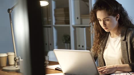 Trabajador-de-oficina-mujer-joven-escribiendo-el-informe-en-la-noche