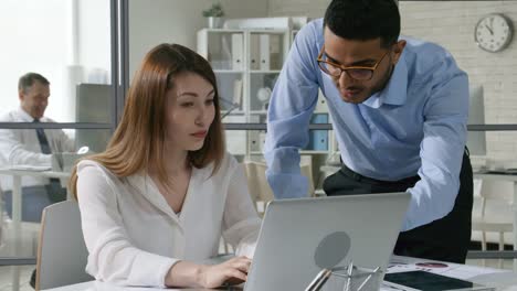 Young-Office-Worker-Helping-Female-Colleague-with-Project